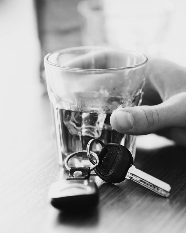 Un vaso corto con hielo sobre la mesa y, delante, las llaves de un auto.